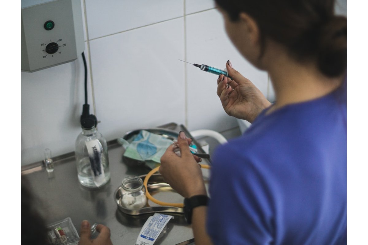 A person preparing a syringe with blue liquid.