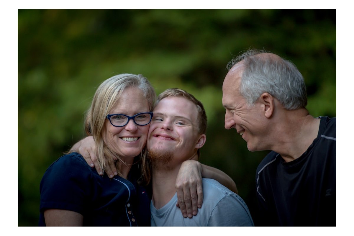 photo of two man and one woman standing near tree
