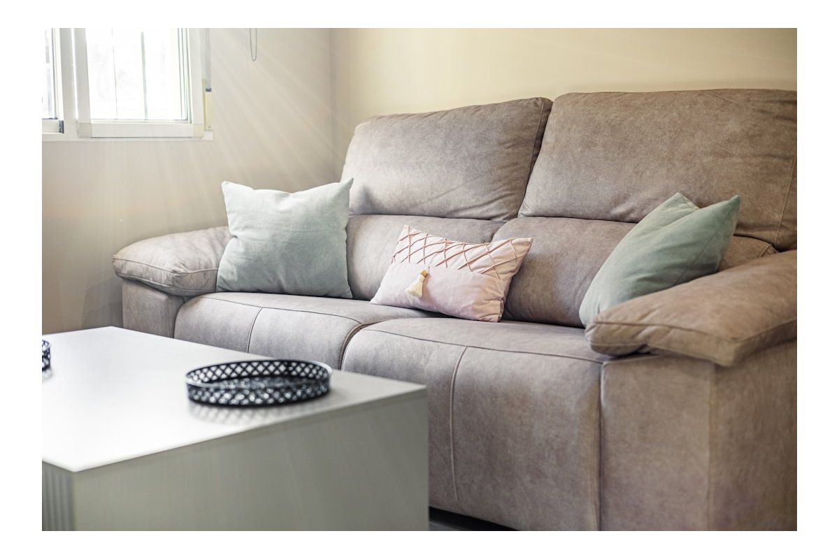 A comfortable sofa with decorative pillows and a coffee table.