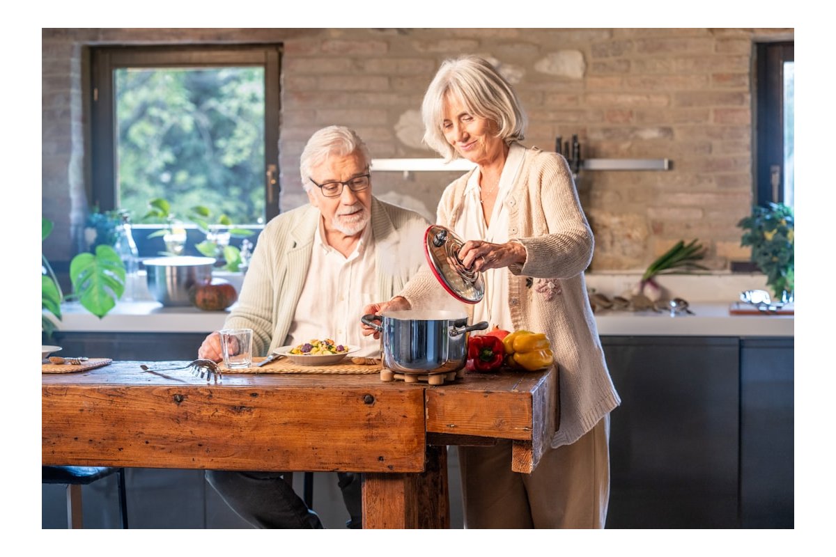 Elderly couple cooking together in a modern kitchen.