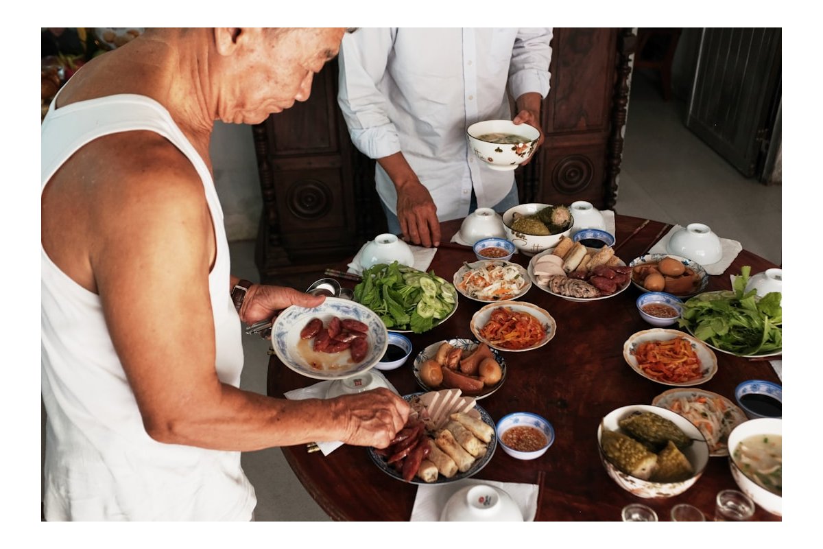 Two people preparing a large meal on a table.