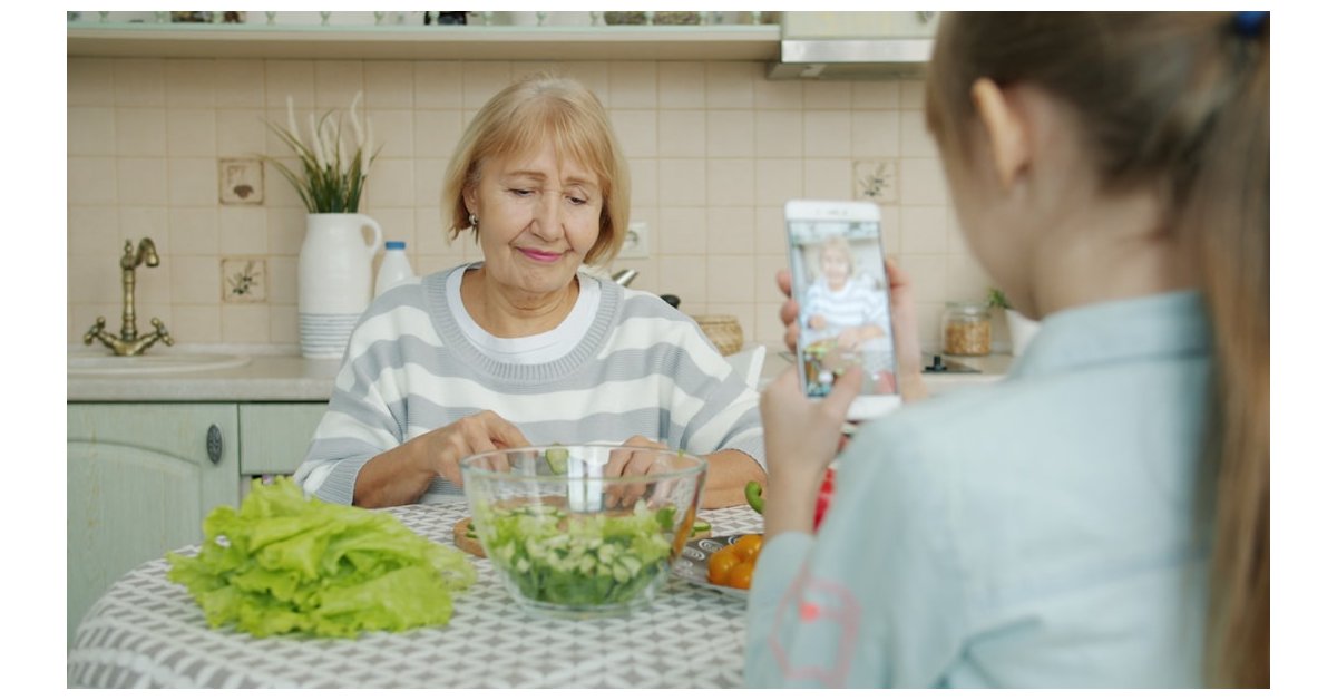 Grandmother and granddaughter making salad in kitchen